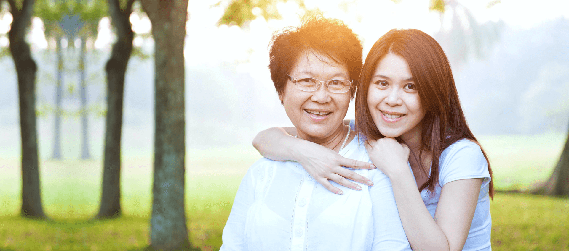 caregiver and an elderly woman smiling at the camera