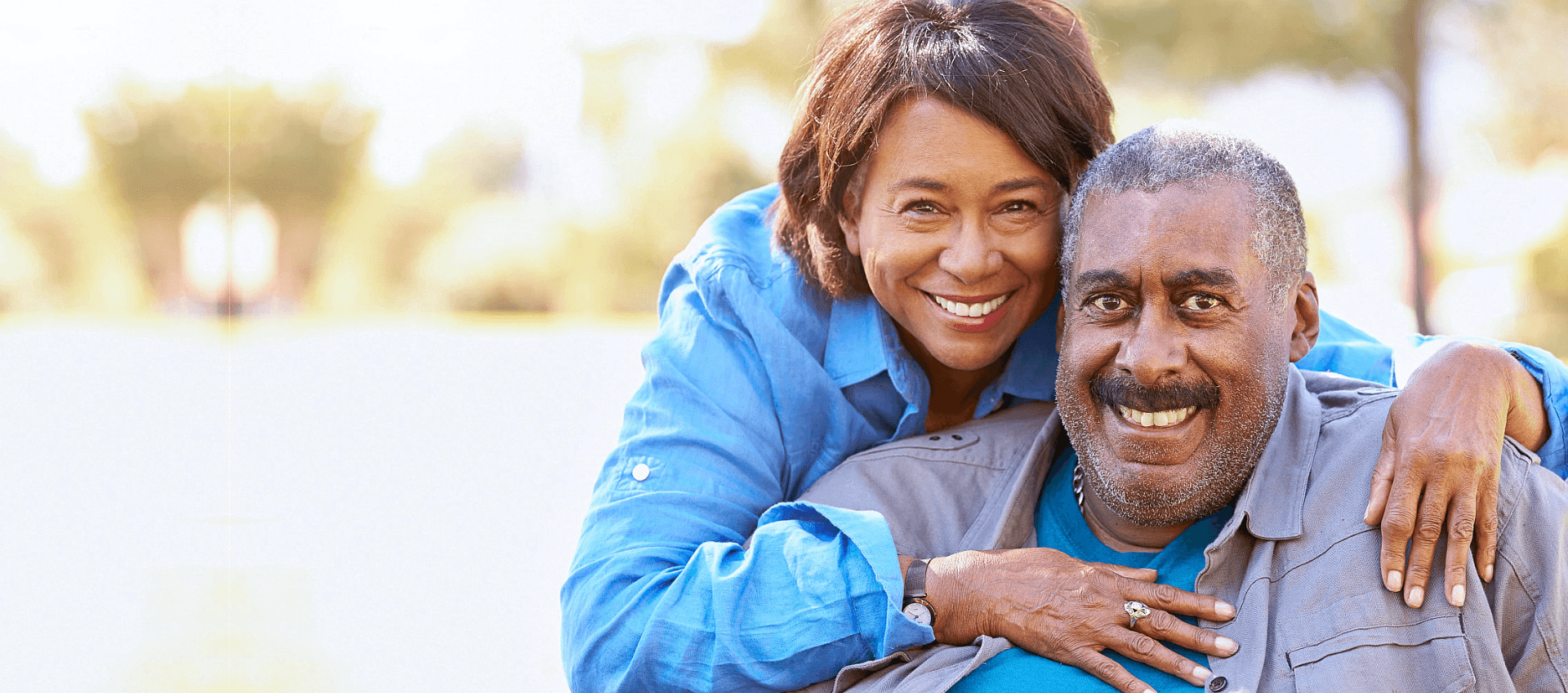 caregiver and an elderly man smiling at the camera