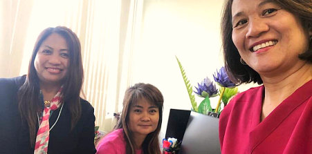 three woman smiling in front of a camera