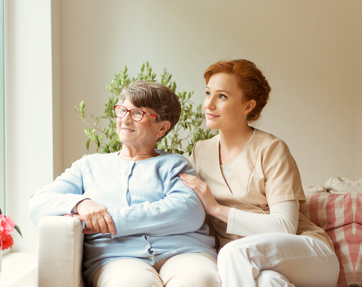 elder woman and caregiver looking out the window