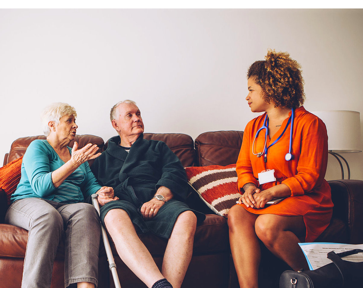 elderly couple talking to a nurse