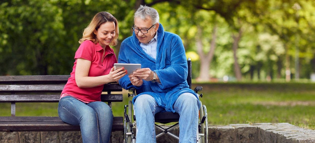 woman and an elder man looking at a tablet