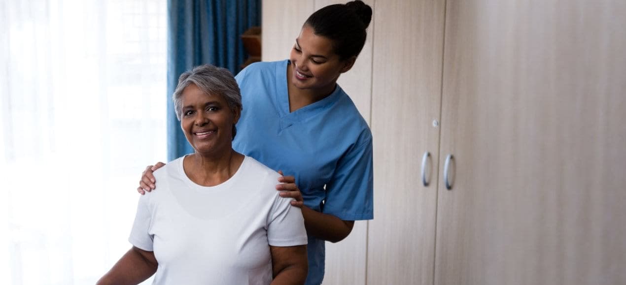 caregiver and elder woman smiling