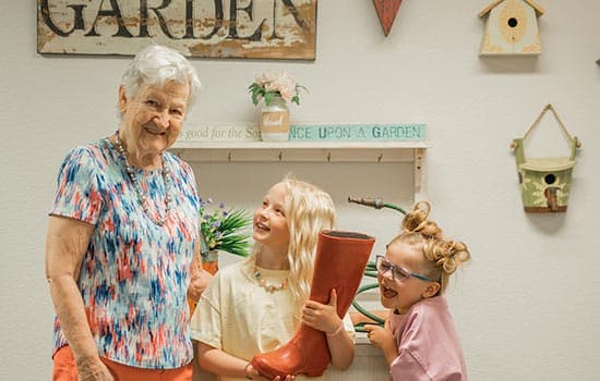 Senior woman smiles with kids thanks to memory care living in Fresno