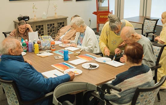 Seniors painting in group as part of memory care living in Fresno